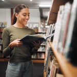 Reading, library book and woman student with a smile about learning, books and college study. Unive.